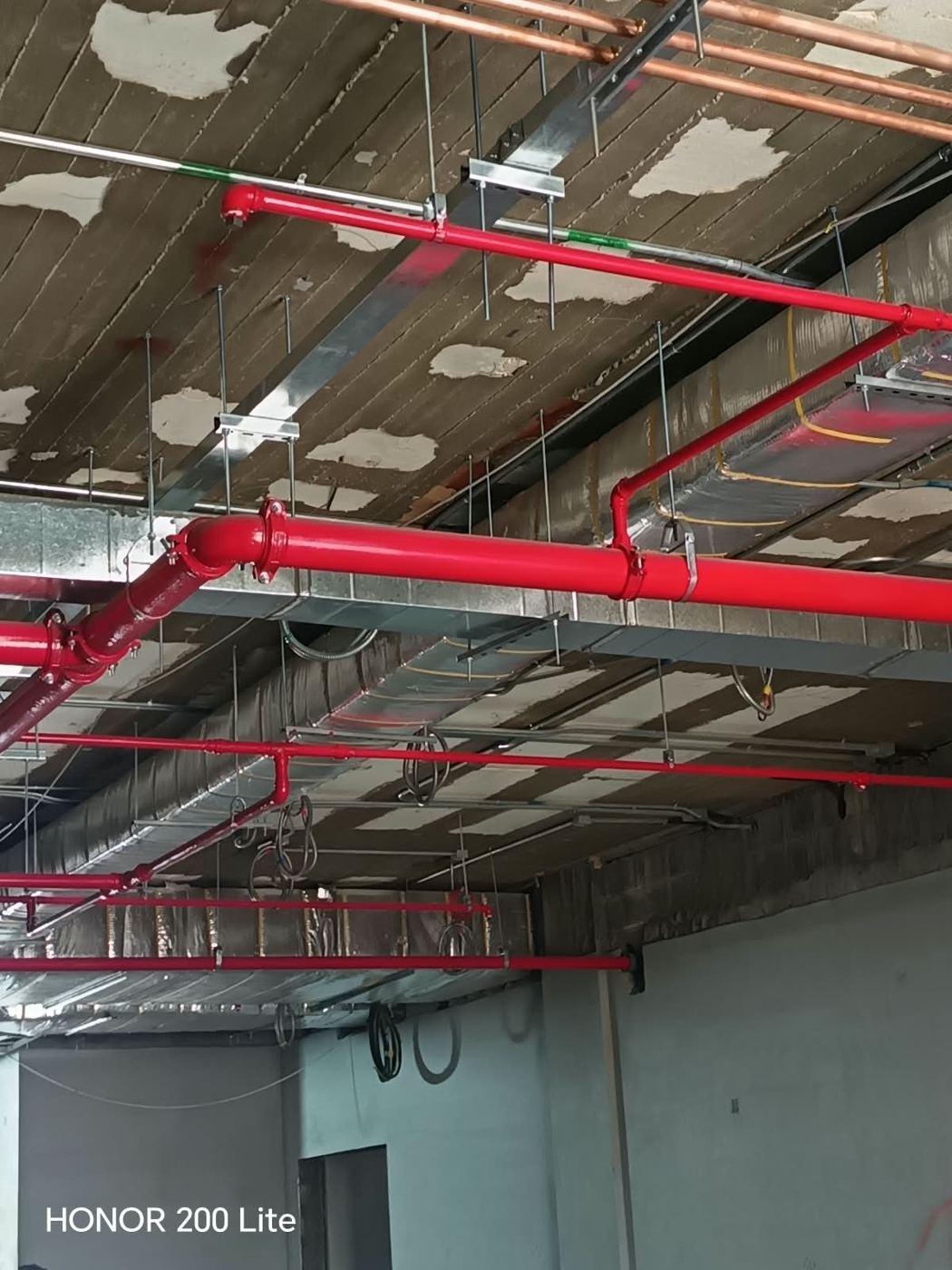 Red fire sprinkler mains at ceiling